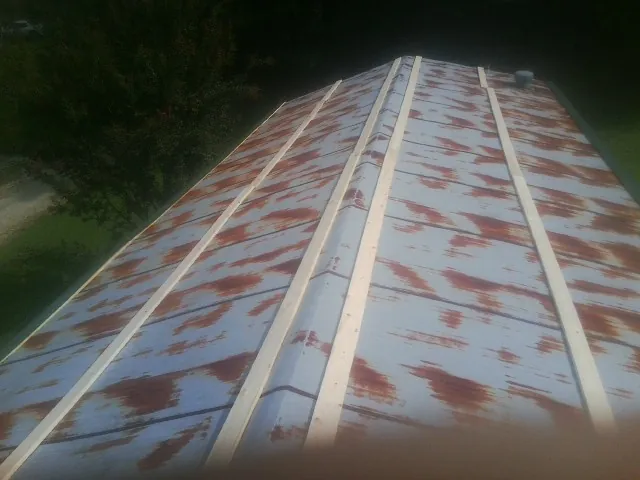 Rusted metal roof panels with new wood purlins before replacement — Storm Damage Roof Repair in Greentown by Roofing Brothers