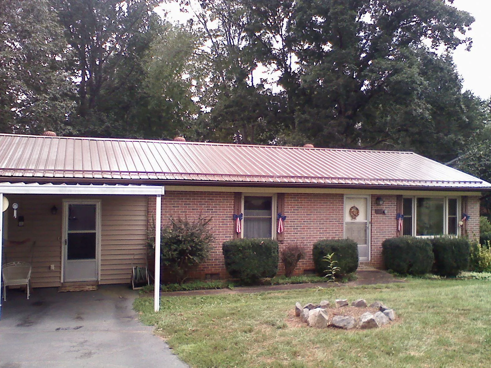 Bronze metal roof and carport on a brick ranch home — Roof Repair work by our crew in Greentown